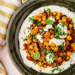 Melanzane e ceci speziati con salsa allo yogurt vegetale serviti in ciotola