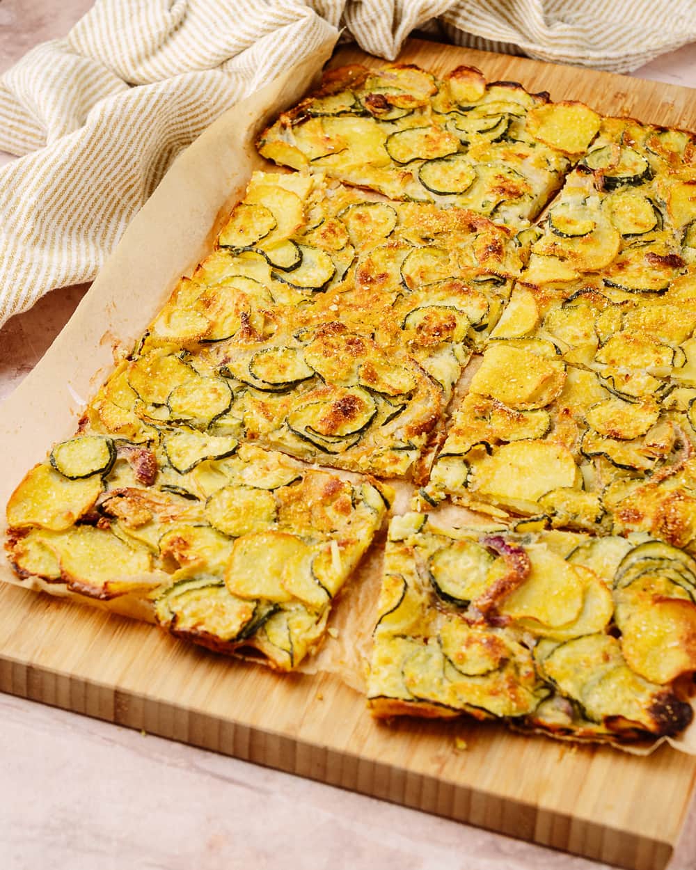 Scarpaccia di zucchine e patate tagliata a rettangoli sul tagliere